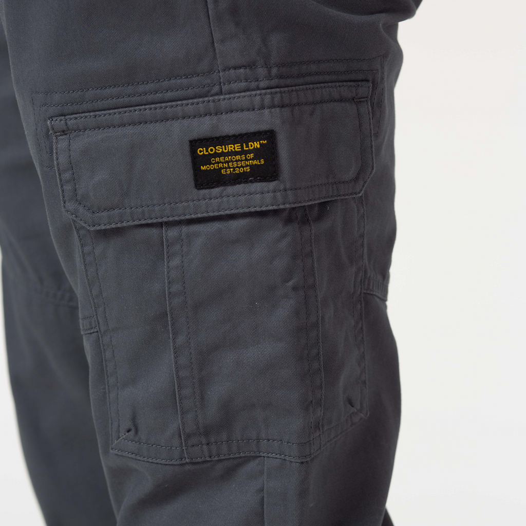 Close up of charcoal grey pocket with black patch and yellow writing