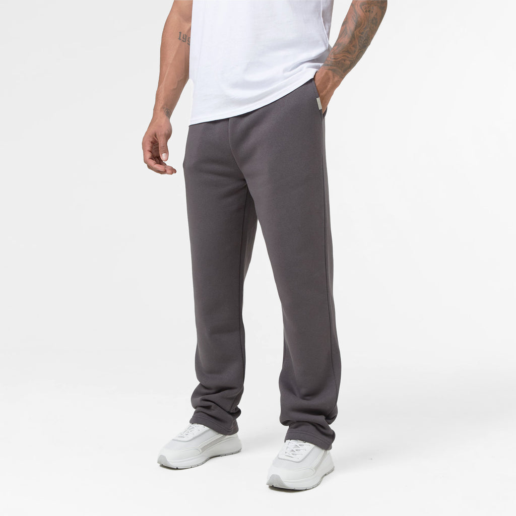 Men's dark grey sweatpants being worn with white trainers