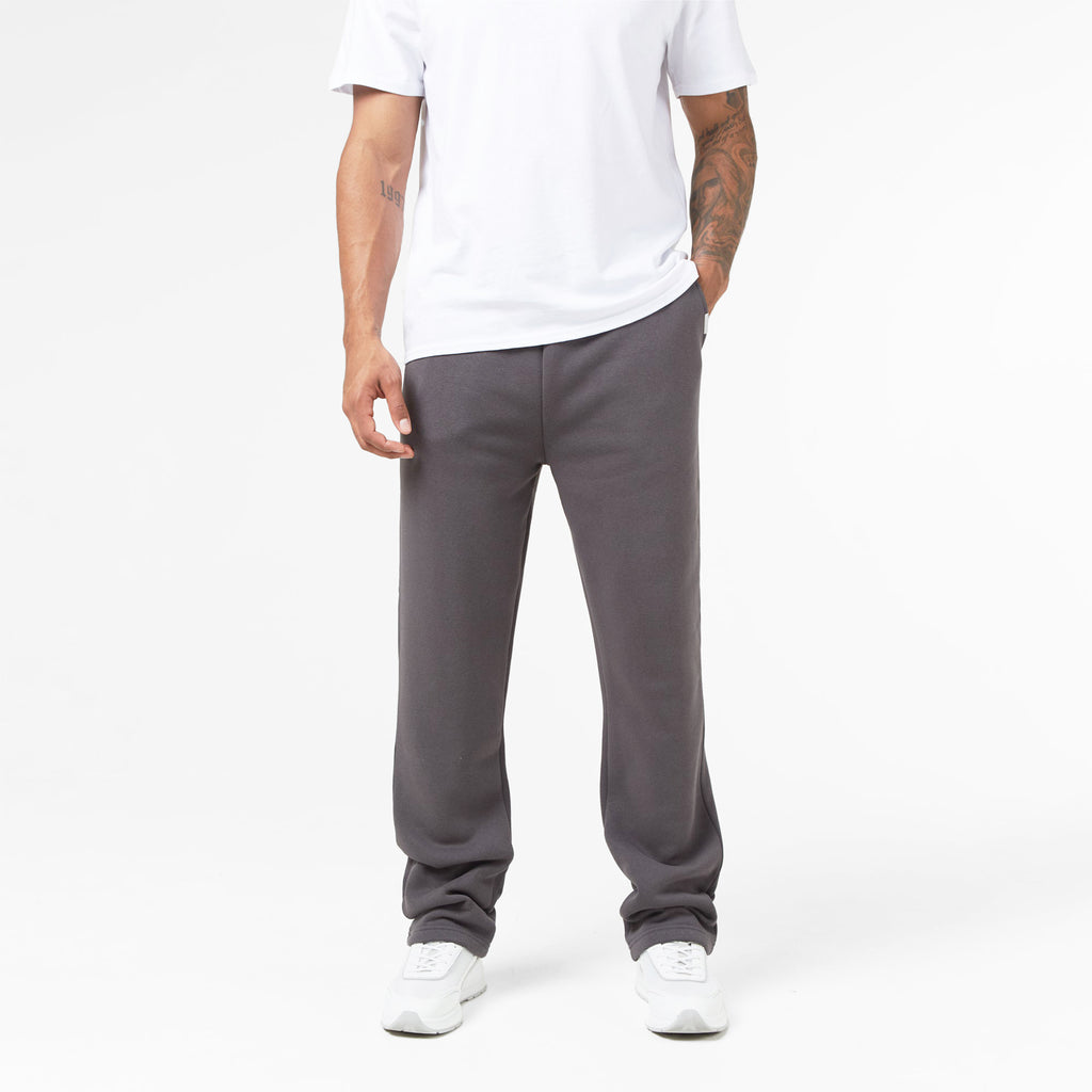 Headless shot of model wearing dark grey sweatpants and white t shirt